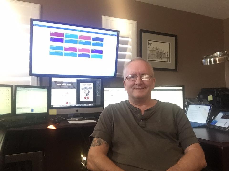 Brian Hussey working on projects with computers in the background.